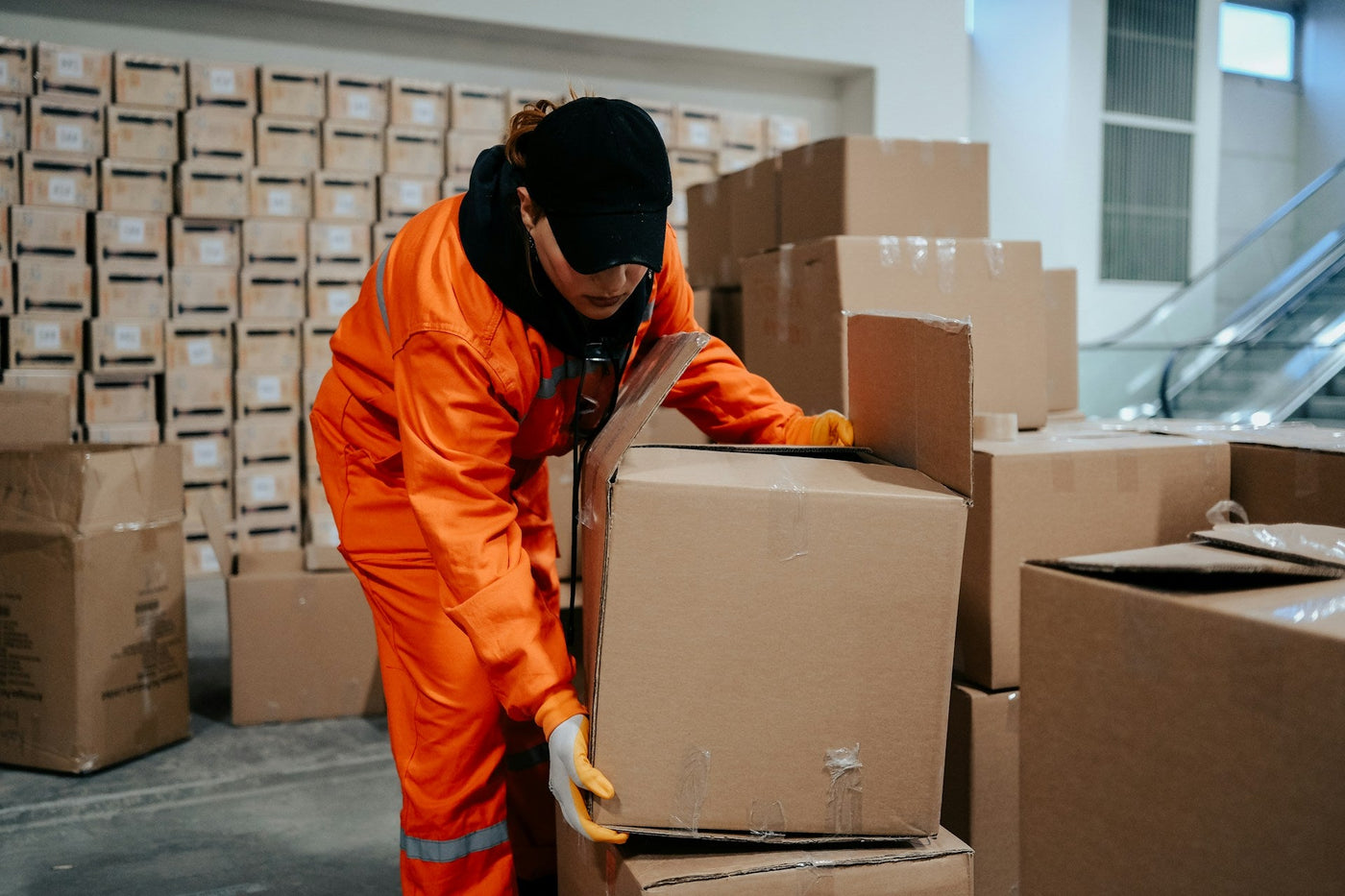 a-person-in-an-orange-coverall-and-a-black-hat